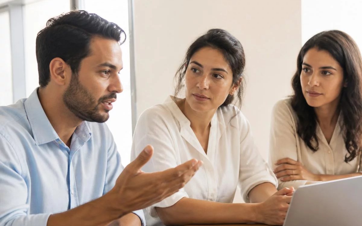 Roda de conversa numa sala clara, com uma pessoa expondo o ponto e duas escutando